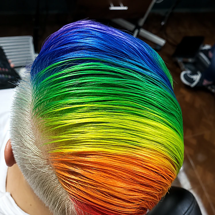Cabello peinado hacia atrás pintado en franjas de azul, verde, amarillo y naranja, visto desde arriba